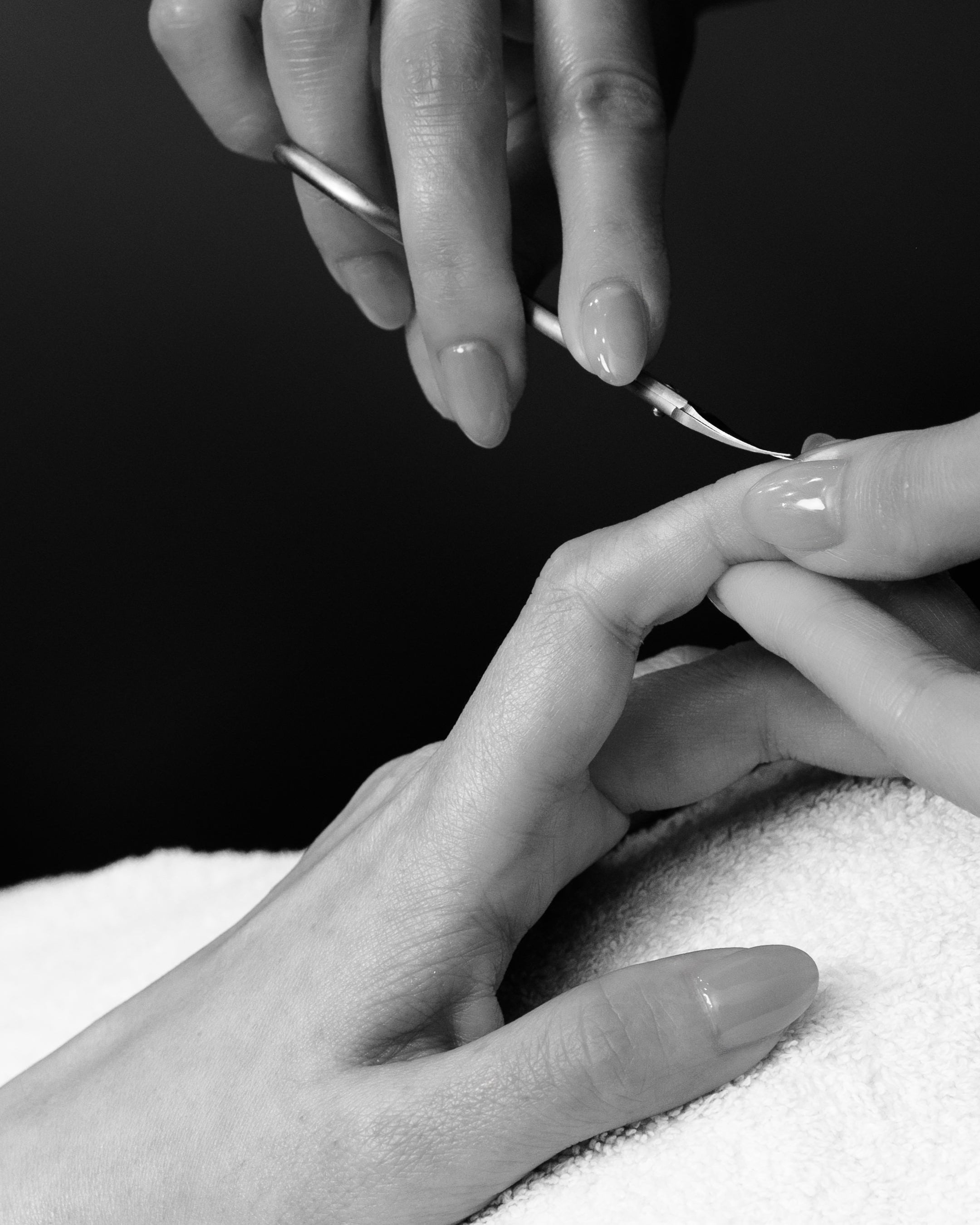 Black and white photo of a hand receiving a manicure.